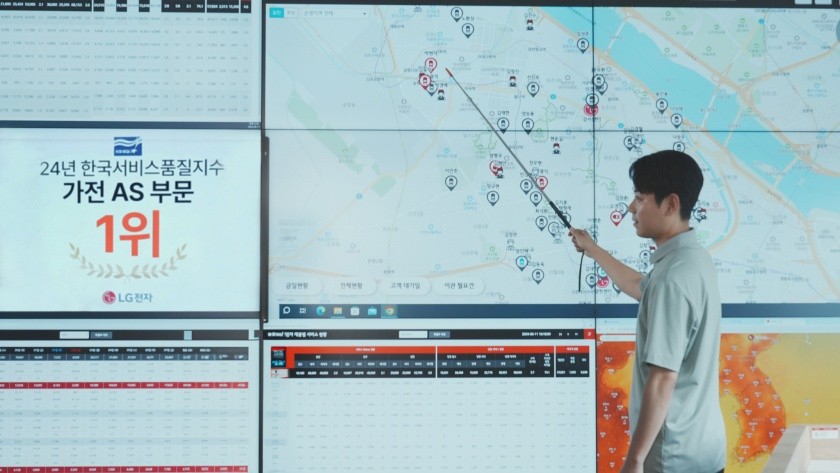 LG전자 서비스 매니저가 GPS 기반 G-CAS 서비스 차량 실시간 모니터링 시스템 앞에서 전국 AS 현황 지도를 가리키는 모습. 옆에 "24년 한국서비스품질지수 가전 AS부문 1위" 인증 배너